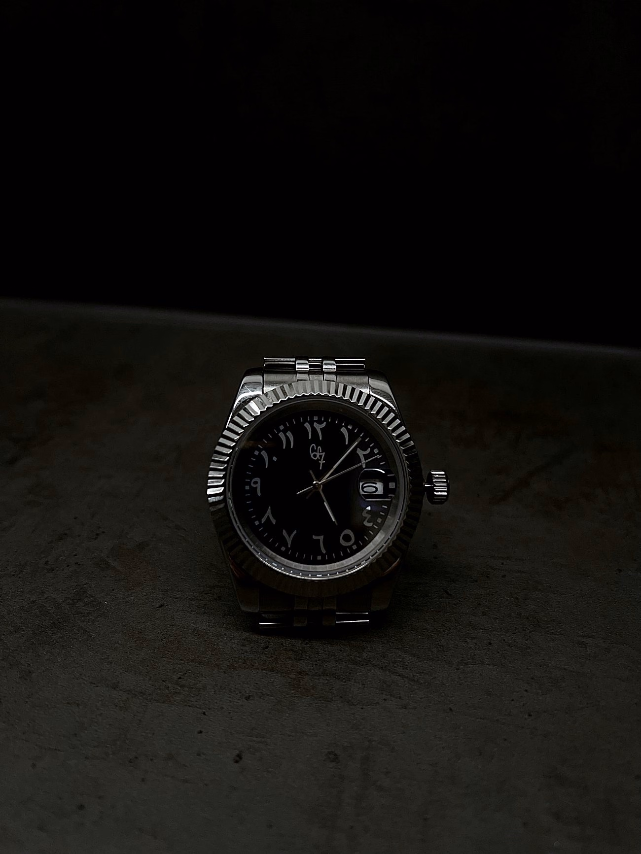 6F7 Noir watch with black dial, Arabic-Indic numerals and silver-toned bracelet.
